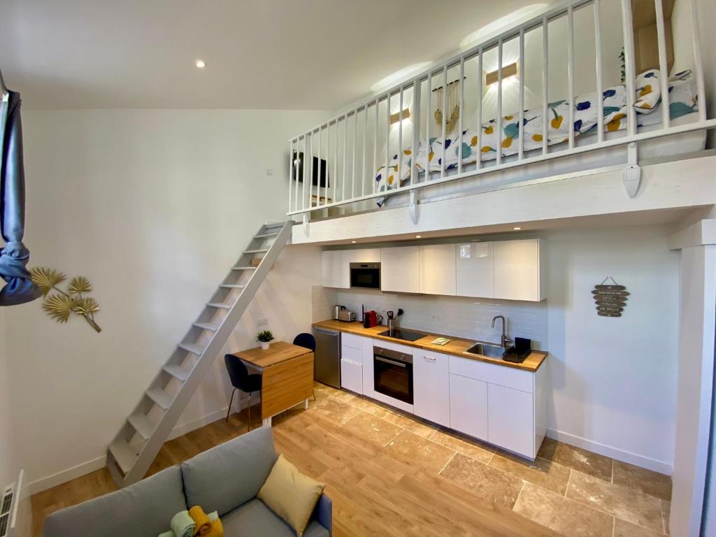 un salon avec une cuisine et un escalier dans l'établissement Chaleureux et Lumineux studio Centre Historique Nimes, à Nîmes
