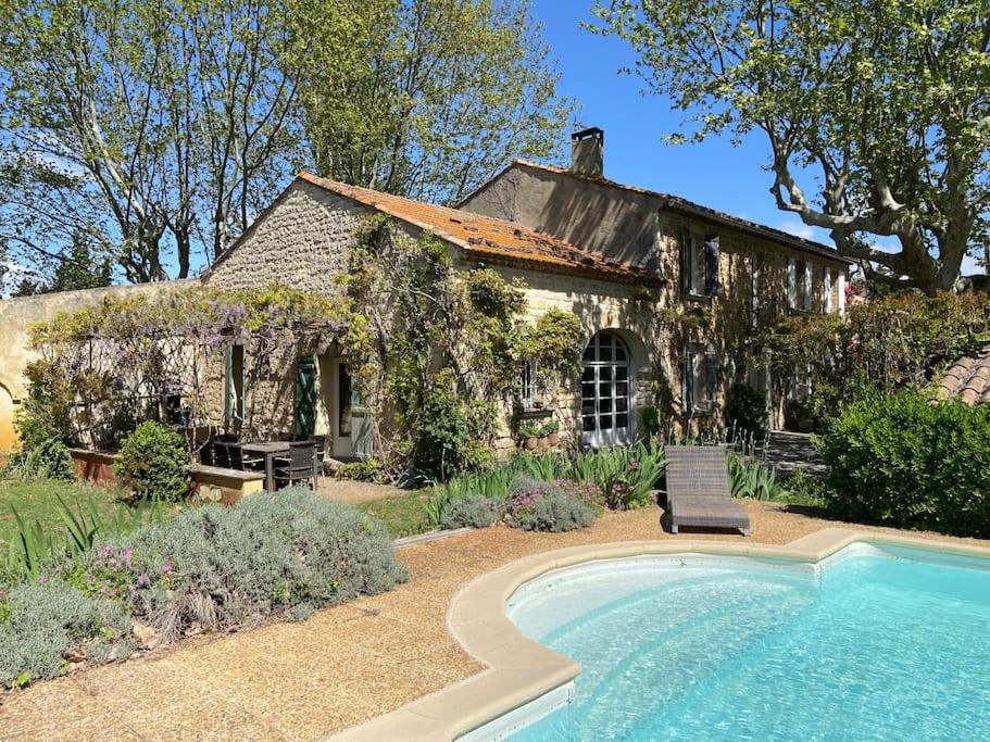 une maison avec une piscine devant une maison dans l'établissement Le Mas Carradou , Mas de Prestige en campagne, à Monteux