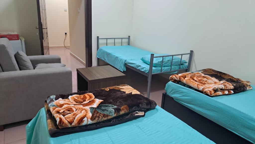a room with two beds and a couch at Room center in Muscat