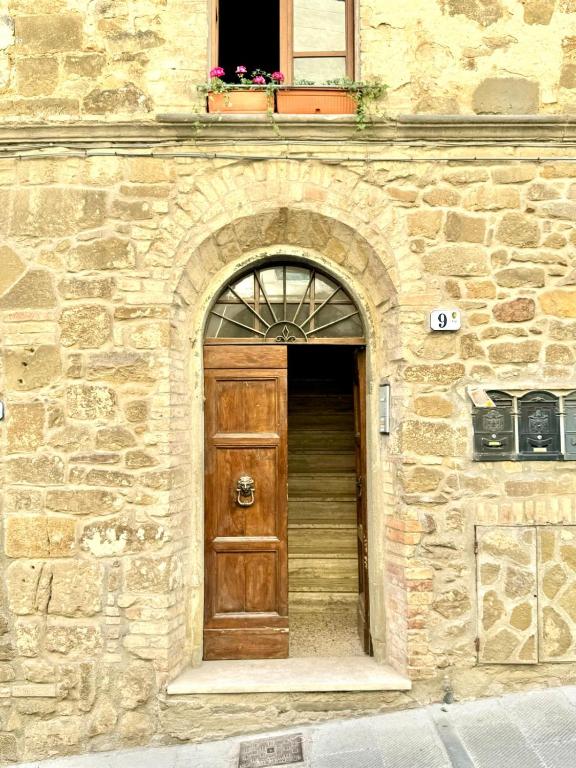 a wooden door in a stone building with a window at MontalciNest in Montalcino