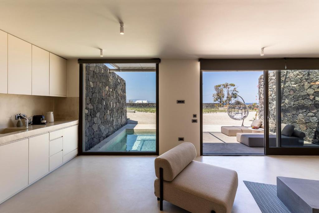 a kitchen and living room with a view of a pool at Santopaz Suites in Oia