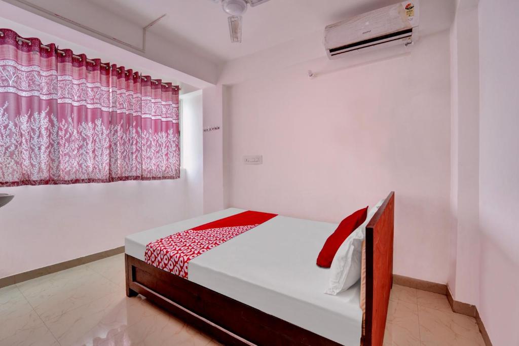 Schlafzimmer mit einem Bett und einem Fenster in der Unterkunft OYO Flagship Hotel Celebrate Inn in Patna