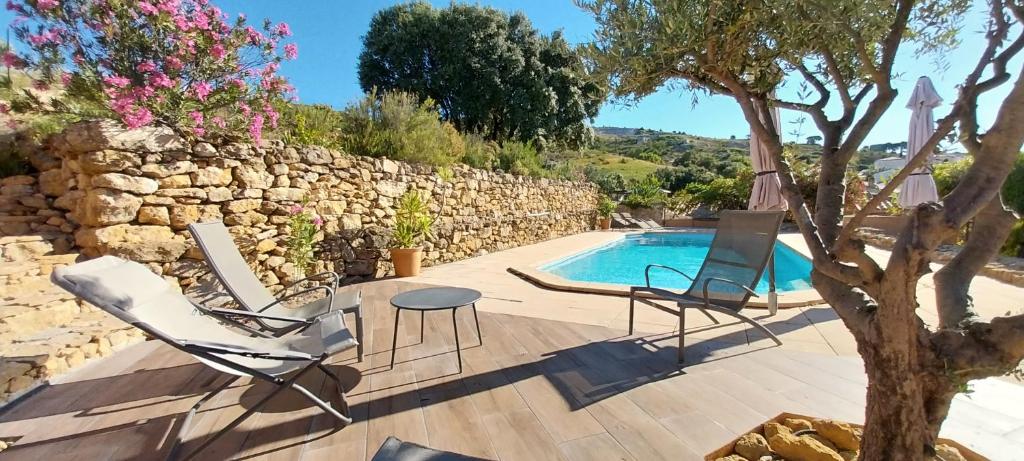 un patio avec des chaises et une piscine dans l'établissement Maison Provençale avec piscine, à Coudoux