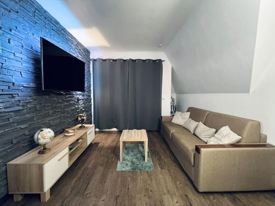 un salon avec un canapé et un mur de briques dans l'établissement Résidence du Golf, à Deauville