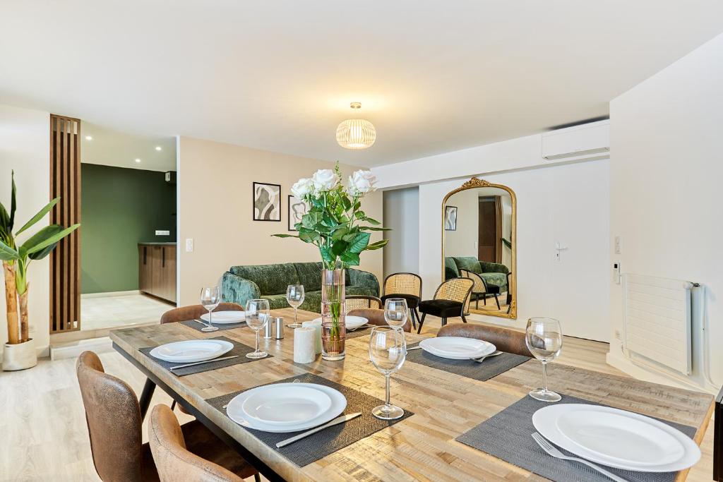 une salle à manger avec une table avec des assiettes et des verres à vin dans l'établissement Résidence Montparnasse by Studio prestige, à Paris