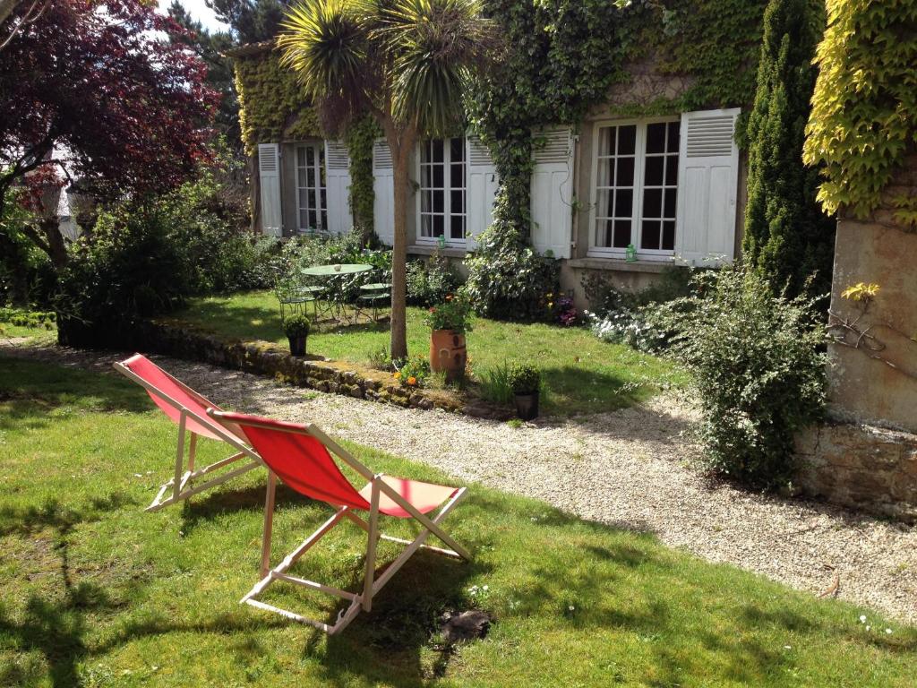deux chaises assises dans l'herbe devant une maison dans l'établissement Les Bleuets, à Saint-Malo
