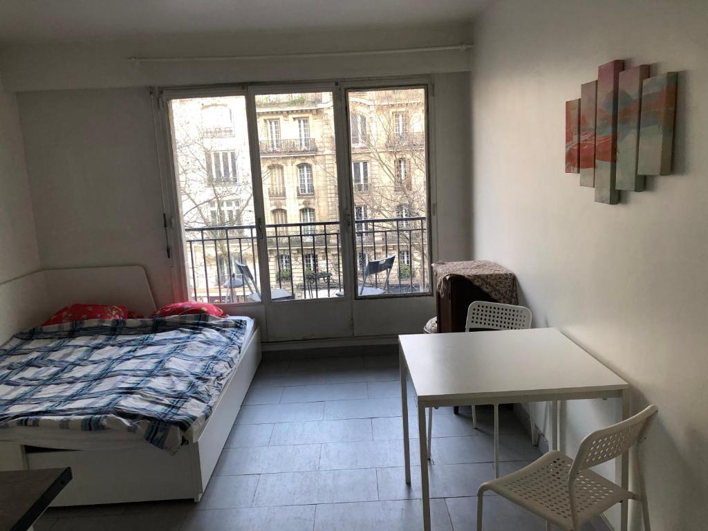 une chambre avec un lit, une table et une fenêtre dans l'établissement Beautiful studio next to metro, à Paris