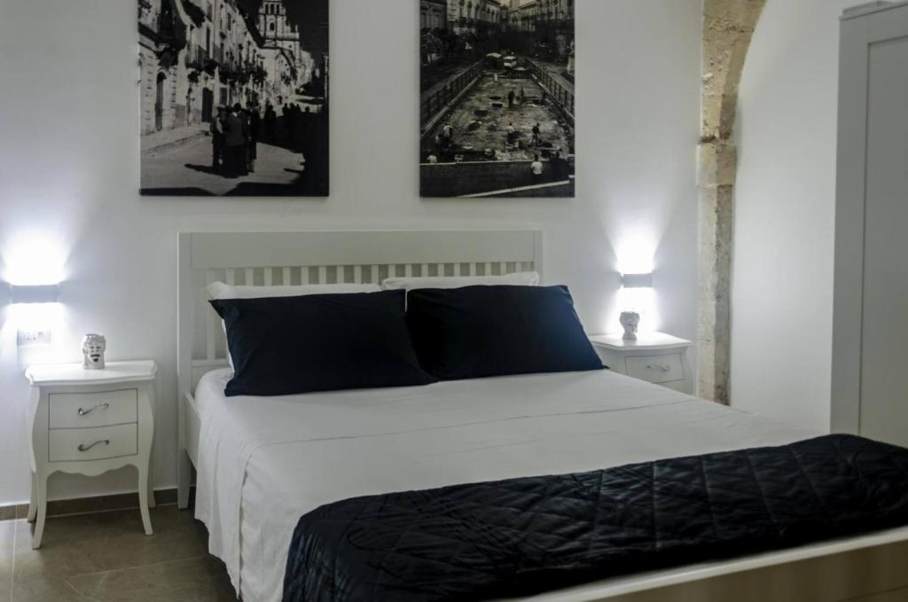 a bedroom with a white bed with two night stands at Marinusa home luxury - air conditioned - wi-fi in Siracusa