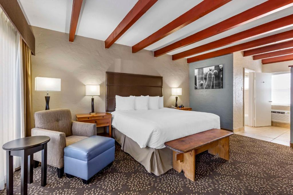 a bedroom with a large bed and a chair at Best Western Mission Inn in Las Cruces