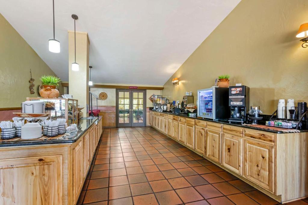 a kitchen with wooden cabinets and appliances in a restaurant at Best Western Mission Inn in Las Cruces
