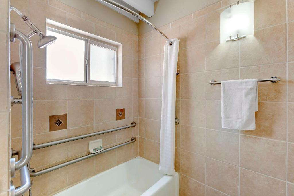 a bathroom with a bath tub and a window at Best Western Mission Inn in Las Cruces