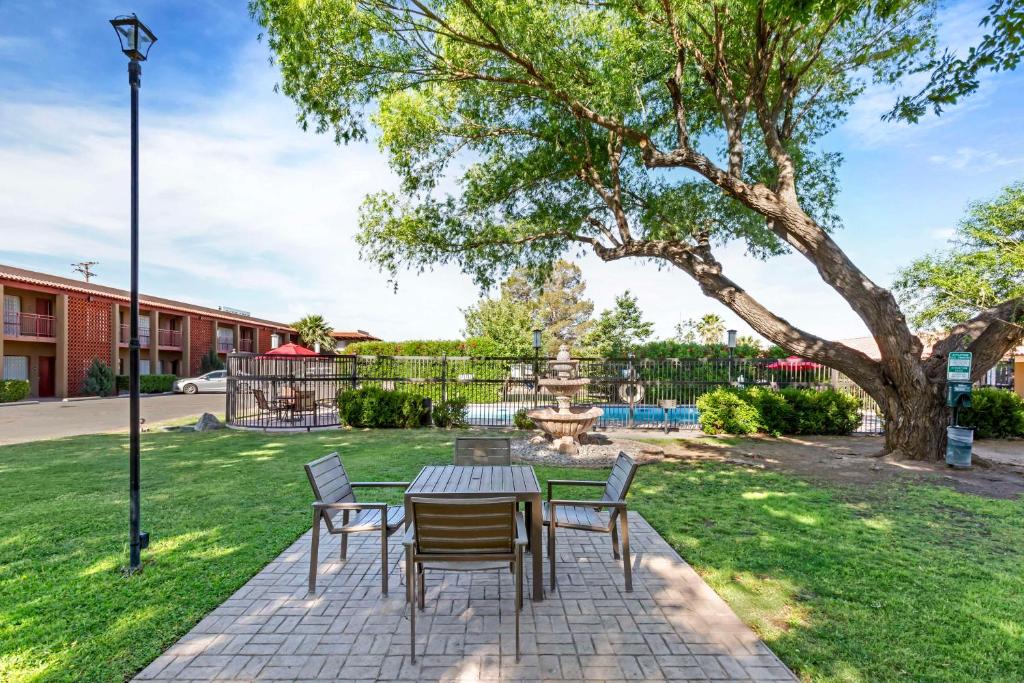 a patio with a table and chairs in a park at Best Western Mission Inn in Las Cruces
