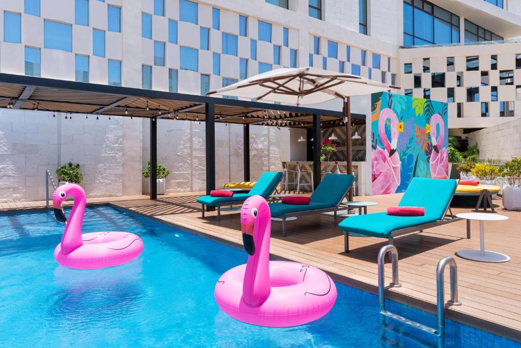 a pool with two pink swans in the water at Avani Cancun Airport -previously NH Cancun Airport- in Canc&uacute;n