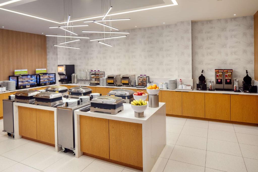 eine große Küche mit einer Theke mit einer Menge Essen in der Unterkunft Hampton Inn by Hilton New York Times Square in New York