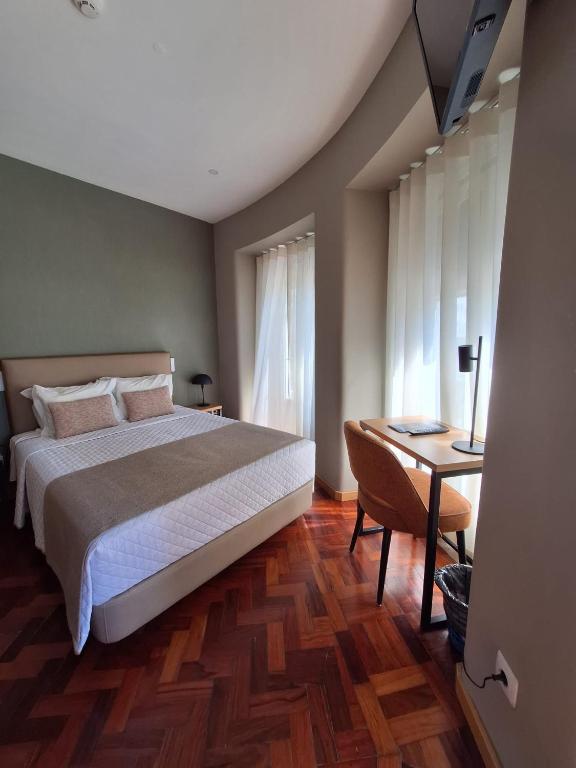 a bedroom with a bed and a desk with a desk at Hotel Alicante Lisboa in Lisbon