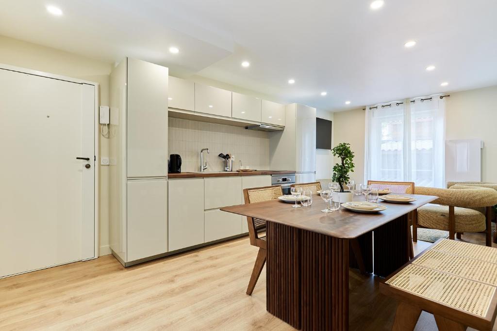 une cuisine et une salle à manger avec une table et des chaises dans l'établissement Résidence Centre de Paris by Studioprestige, à Paris