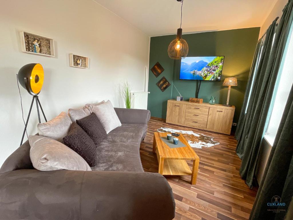 a living room with a couch and a tv at Strandbude 2 Döse in Cuxhaven
