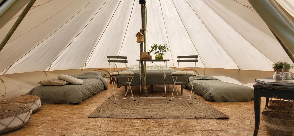 a tent with a table and chairs in it at Petit a Petit - gypsy wagons and Bell tents in the Bourgogne in Saisy