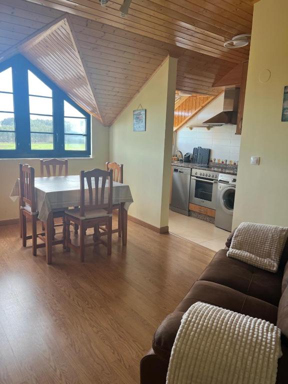 a kitchen and dining room with a table and chairs at Las Catedrales ático Oceano VI in Barreiros