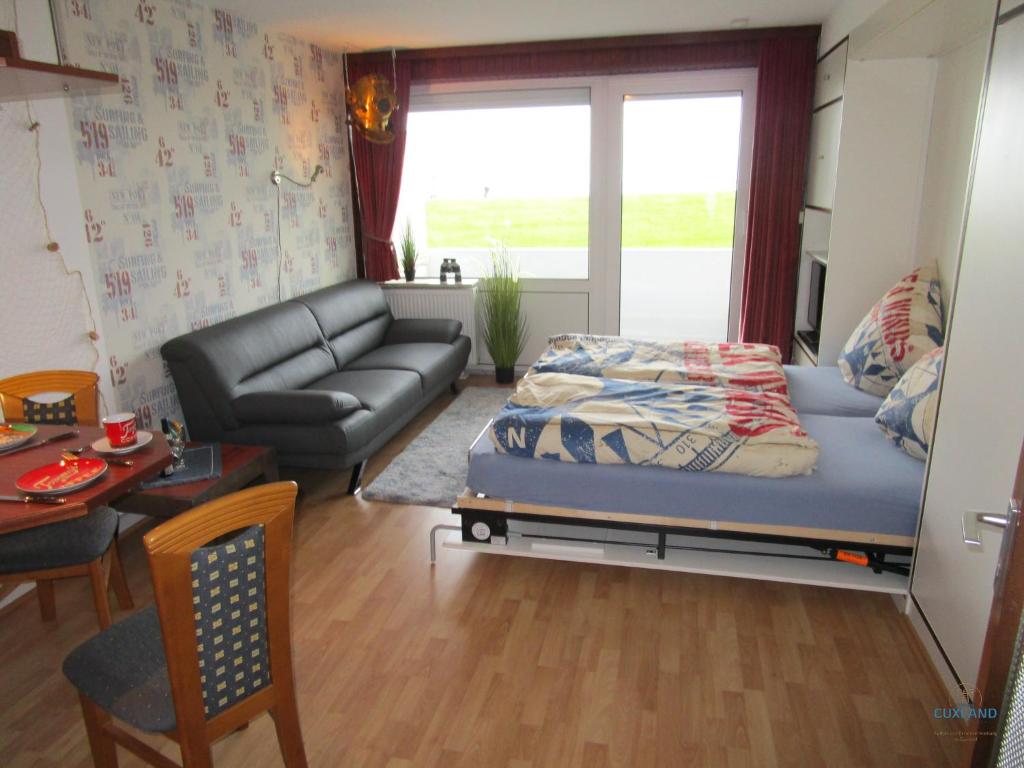 a living room with a bed and a couch at Ferienwohnung 223 Haus Nautic in Cuxhaven