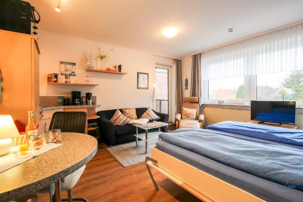 クックスハーフェンにあるStrand und zentrumsnahe Ferienwohnung für bis zu 2 Personen in Döseのベッドとリビングルームのある寝室