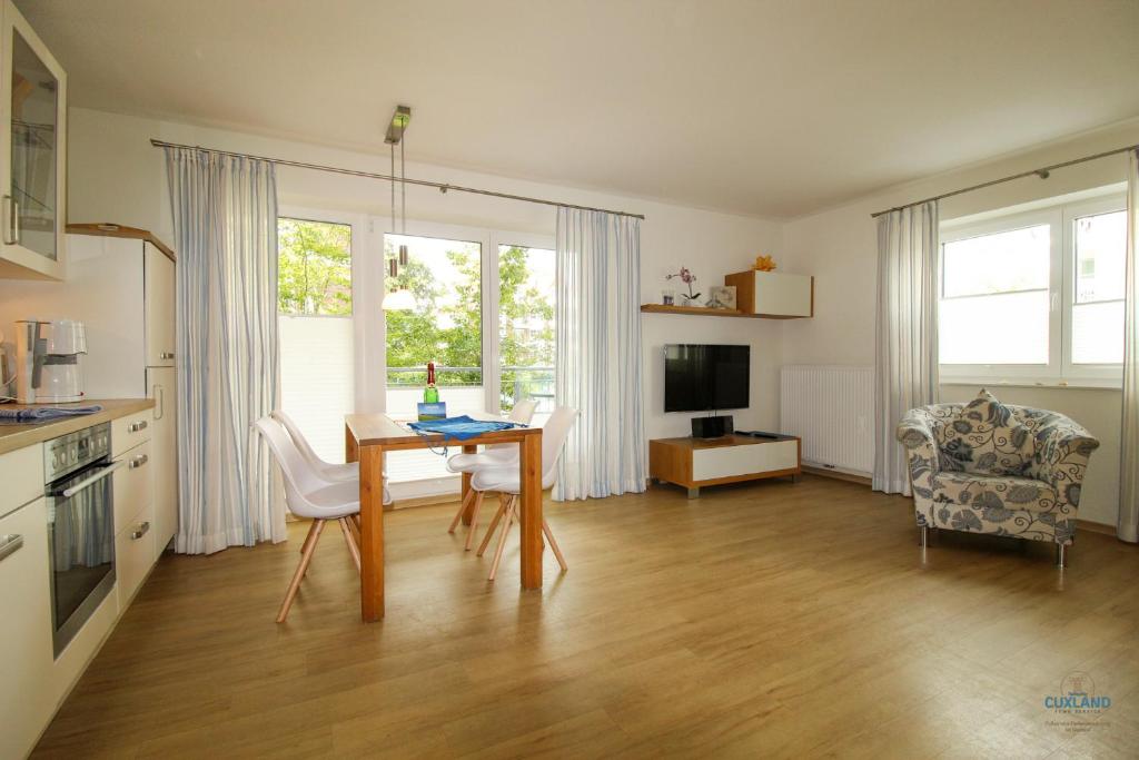 eine Küche und ein Wohnzimmer mit Tisch und Stühlen in der Unterkunft Residenz Hohe Lith Wohnung 04 01 in Cuxhaven