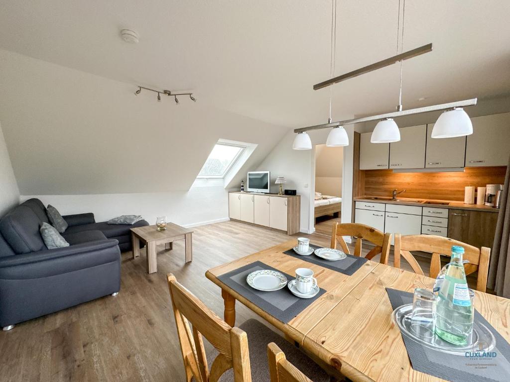 a living room and kitchen with a table and a couch at Refugium Storchenwiese Wohnung 2 in Cuxhaven