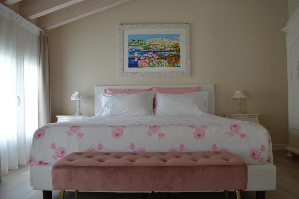 sypialnia z dużym łóżkiem z różowymi kwiatami w obiekcie B&B La Fiaba w Sirmione