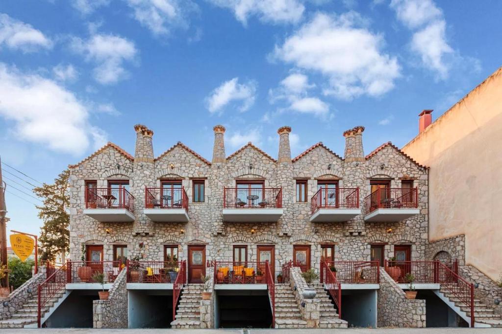 an old stone building with red balconies and stairs at Stone Villas Dukes in Paralion astros