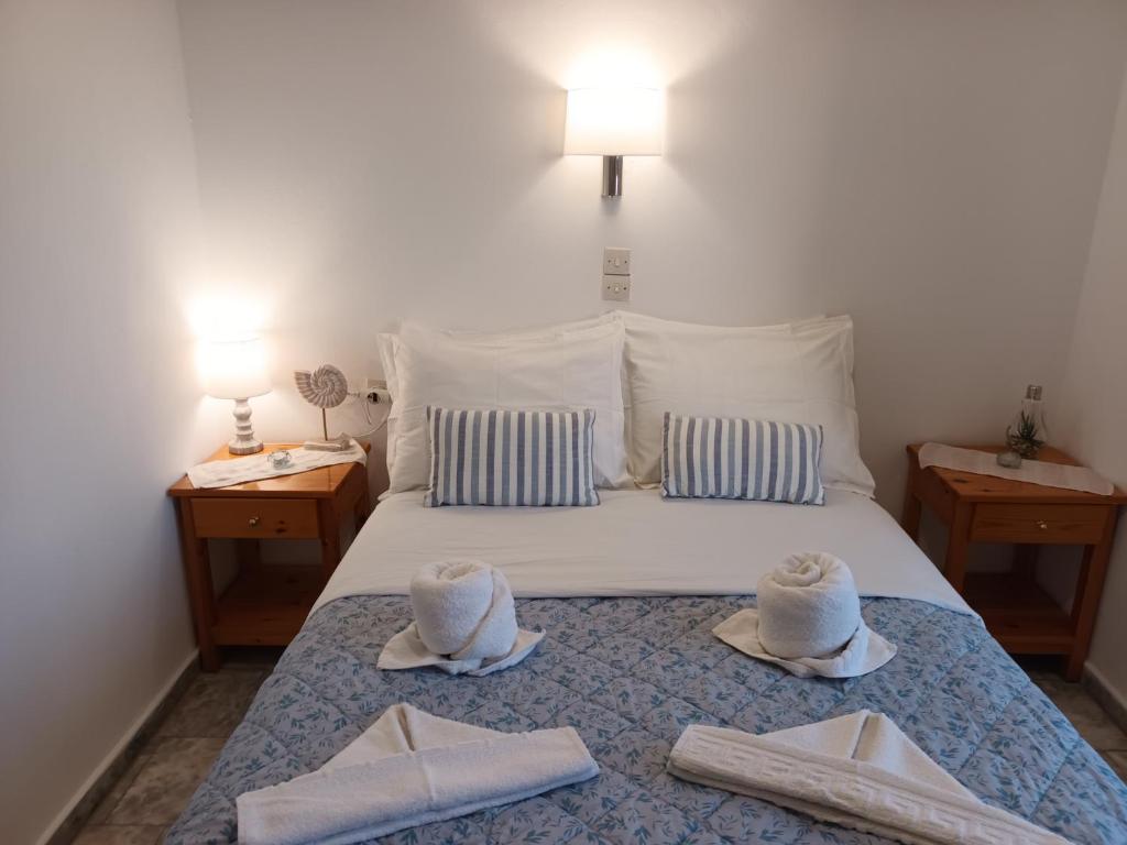 a bed with two towels and two hats on it at Massouri Rooms in Masouri