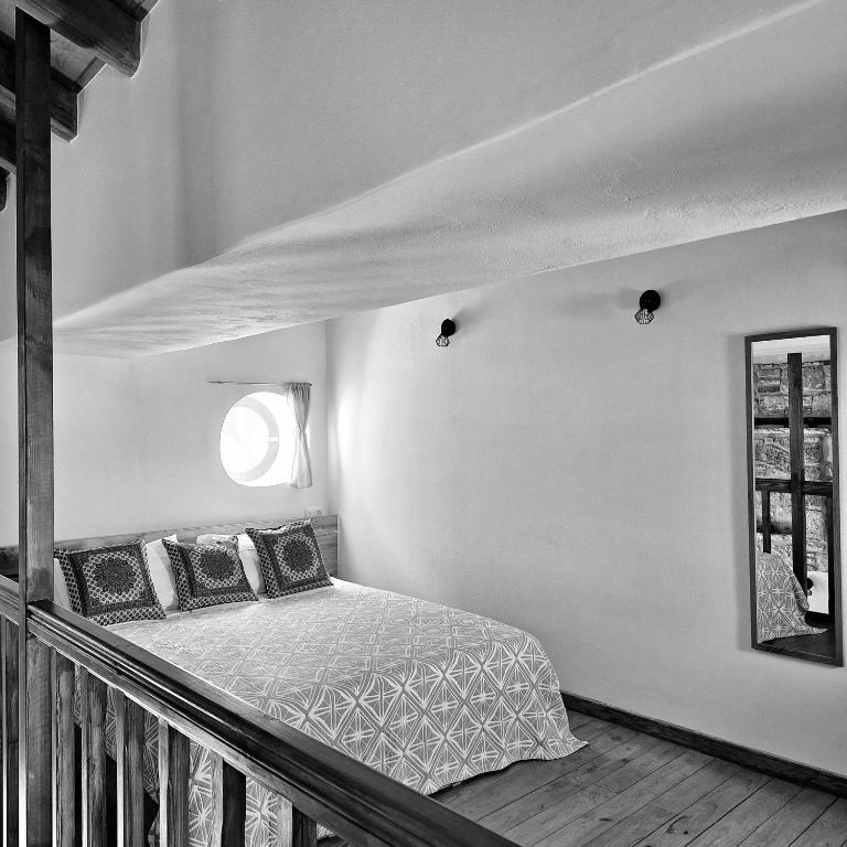 a bedroom with a bed with pillows and a window at To Pefko - Mezzanines - in Meyisti