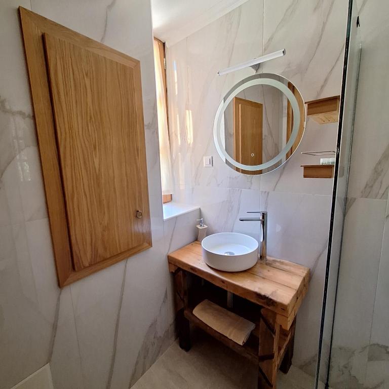 a bathroom with a sink and a mirror at To Pefko - Mezzanines - in Meyisti