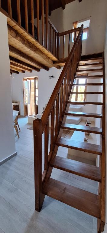 a wooden staircase in a room with a ceiling at To Pefko - Mezzanines - in Meyisti