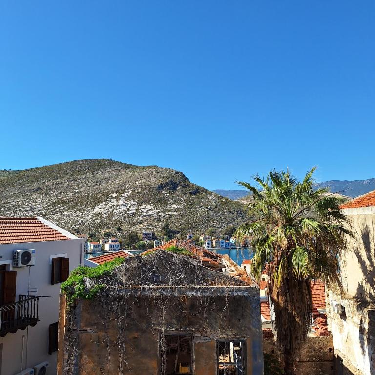 a view of a city with palm trees and a mountain at To Pefko - Mezzanines - in Meyisti