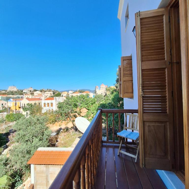a balcony with a wooden door and a bench at To Pefko - Mezzanines - in Meyisti
