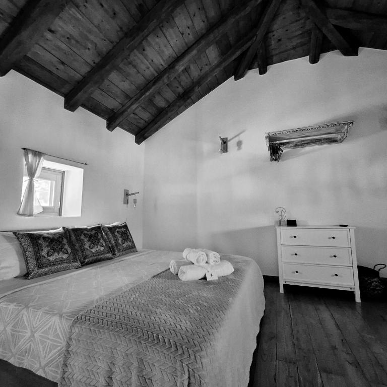 a bedroom with a bed with two towels on it at To Pefko - Mezzanines - in Meyisti