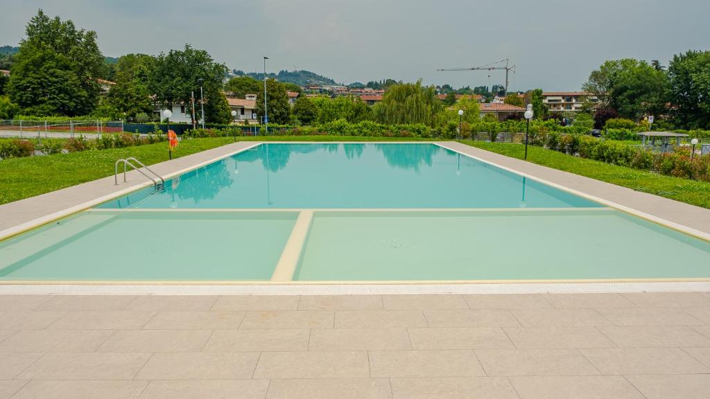 ein großer leerer Pool mit blauem Wasser in der Unterkunft Rosa Dei Venti - Italian Homing in Padenghe sul Garda