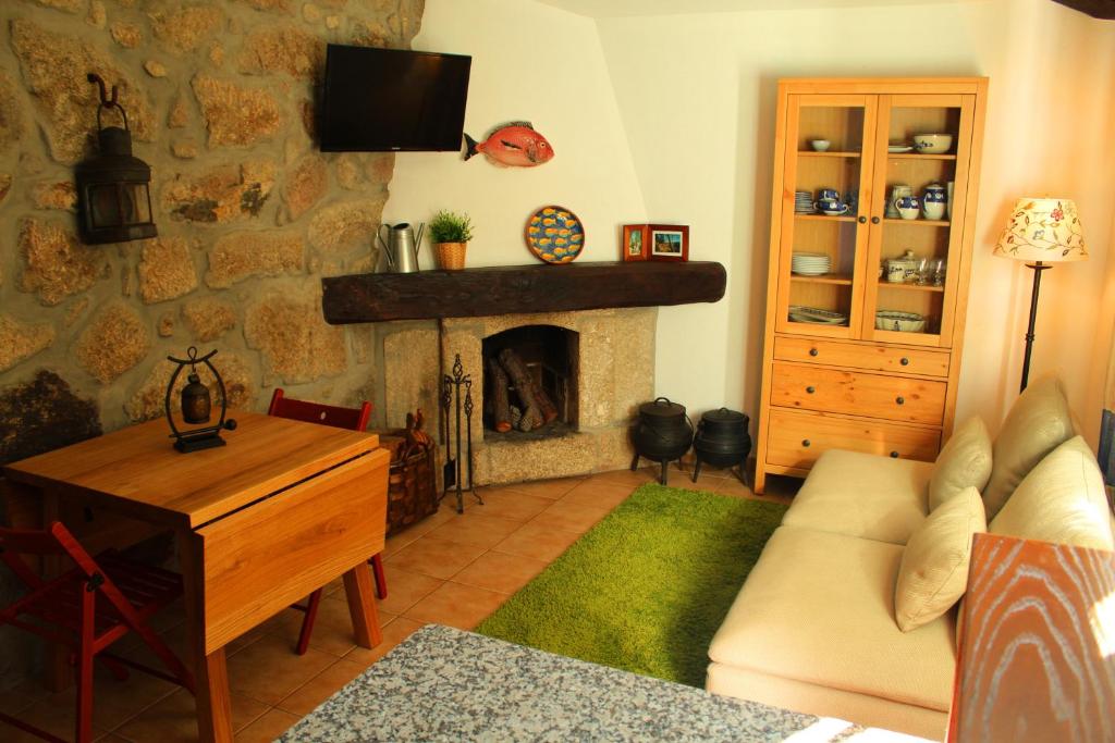 a living room with a couch and a fireplace at Casa do Rio - Eido do Pomar in Arcos de Valdevez