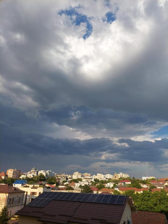 克拉约瓦Best City View的天空阴云密布、屋顶装有太阳能电池板的城市