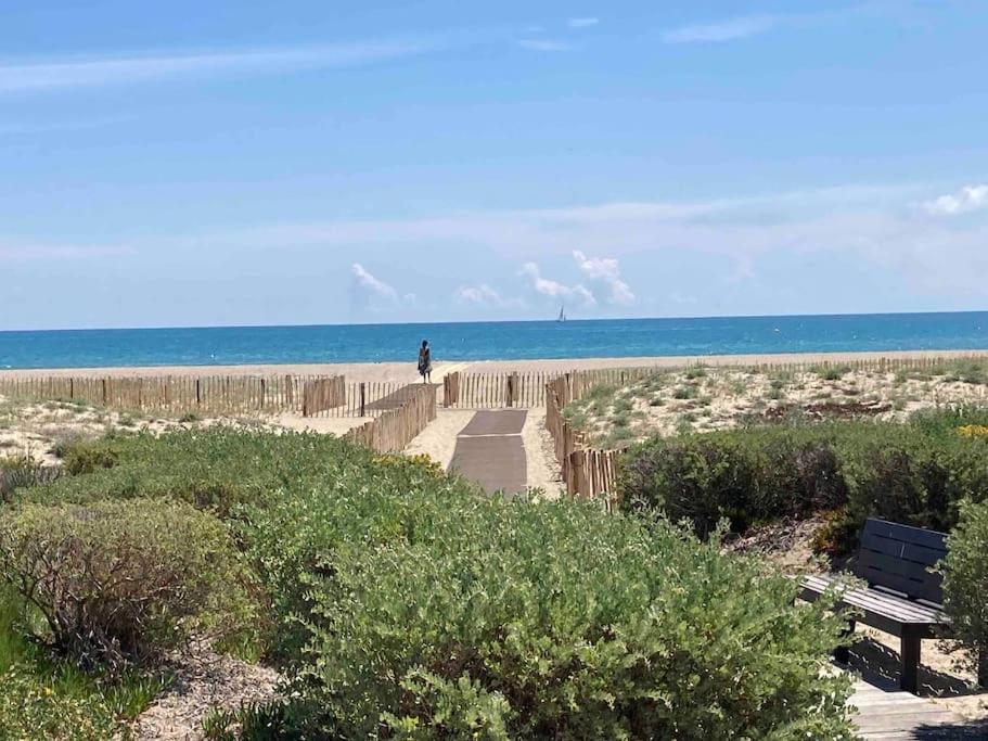 une personne se promenant sur un chemin menant à la plage dans l'établissement Apt T2 bis, Relax en front de mer, piscine à Port Leucate, à Leucate
