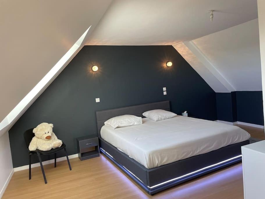 a bedroom with a bed with a teddy bear on a table at Gîte de charme Moyrazes in Moyrazès