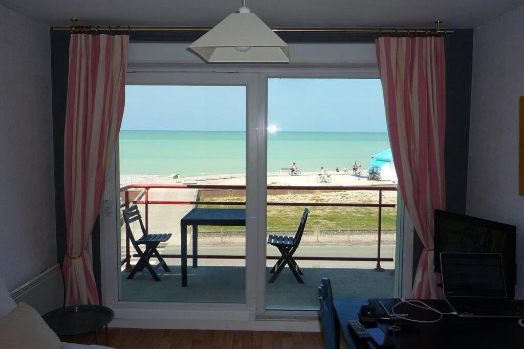 Cette chambre dispose d'une grande fenêtre offrant une vue sur la plage. dans l'établissement Appartement face à la mer, à Criel-sur-Mer