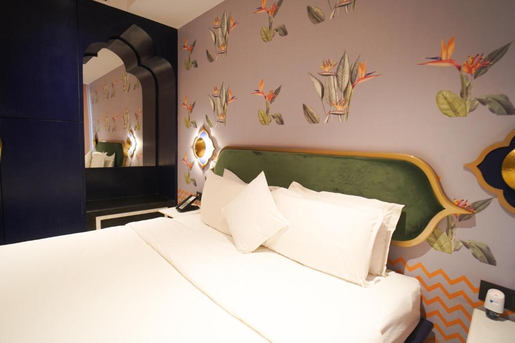 a bedroom with a bed with white pillows at Bur'Dera - a Boutique Luxury Hotel in Jaipur