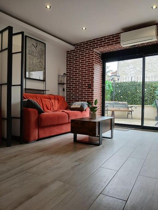 un salon avec un canapé rouge et une table dans l'établissement Disneyland Paris Studio avec Terrasse, à Chalifert