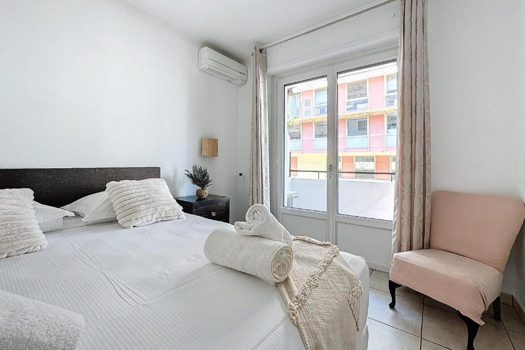 une chambre avec un lit, une chaise et une fenêtre dans l'établissement LES MIMOSAS - Ideal Congress - Apartment for 4 people in Cannes, à Cannes