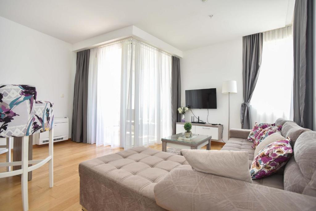 a living room with a couch and a television at Apartman Drobnjak Center-sea View in Budva