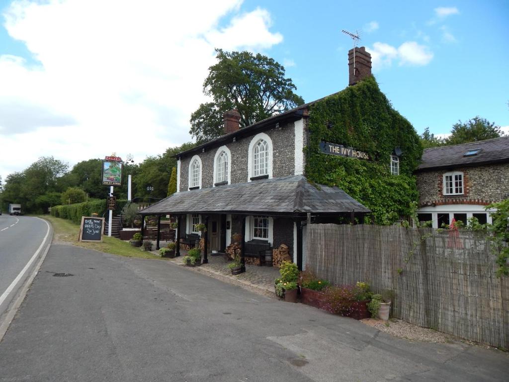 een met klimop bedekt gebouw aan de kant van een weg bij The Ivy House in Chalfont Saint Giles