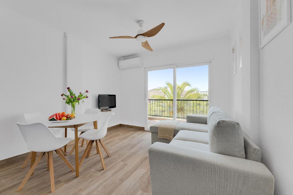 un salon blanc avec une table et un canapé dans l'établissement Apartament Palmside Torrevieja, à Torrevieja