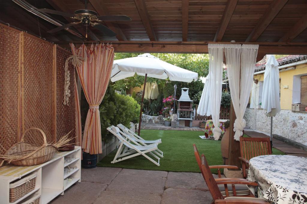 un patio con mesa, sillas y sombrilla en Casa Rural Siguenza Domus 200m2 de Vivienda y Exterior, en Sigüenza