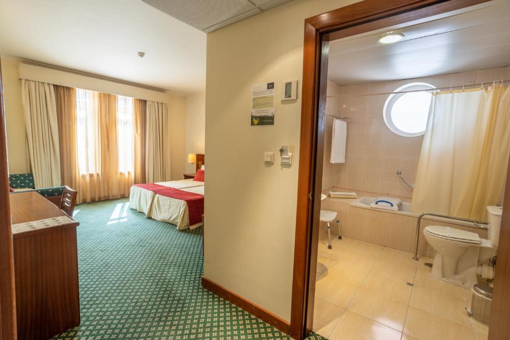 um quarto de hotel com uma cama e um banheiro em Hotel Eurosol Gouveia em Gouveia